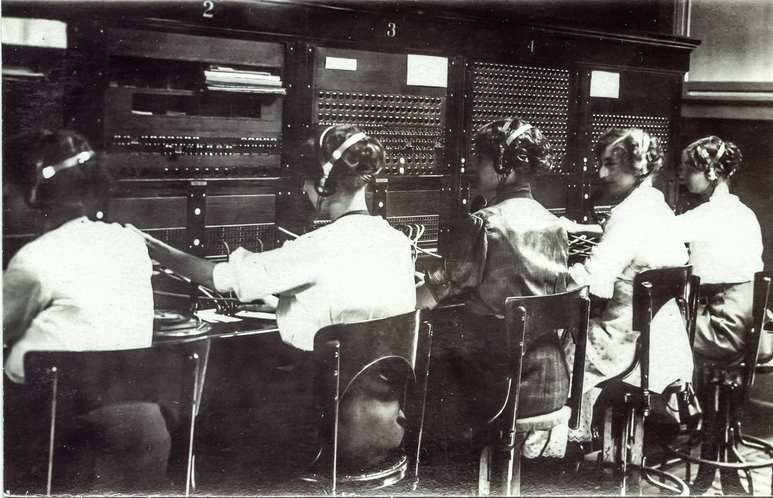 Black-and-white photograph of telephone operators seated at a switchboard